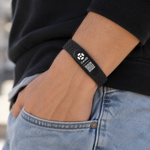 Black CareID Bracelet worn on a wrist beside a jeans pocket